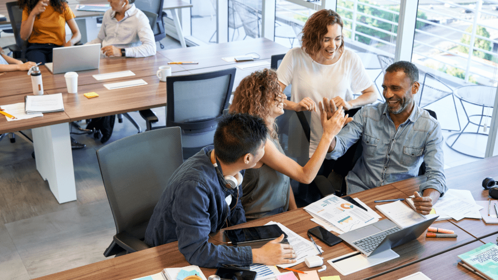 Four workers talking to each other around a desk