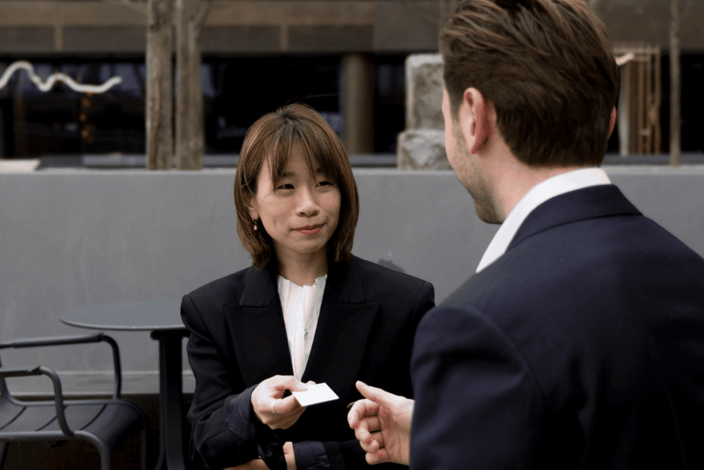 smiling businessman and businesswoman exchanging a business card