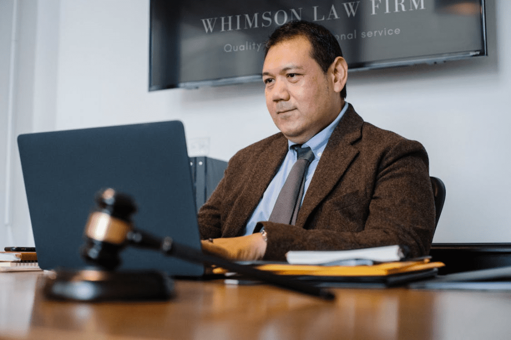 Legal recruiter reviewing remote candidate profiles on a laptop inside a law office