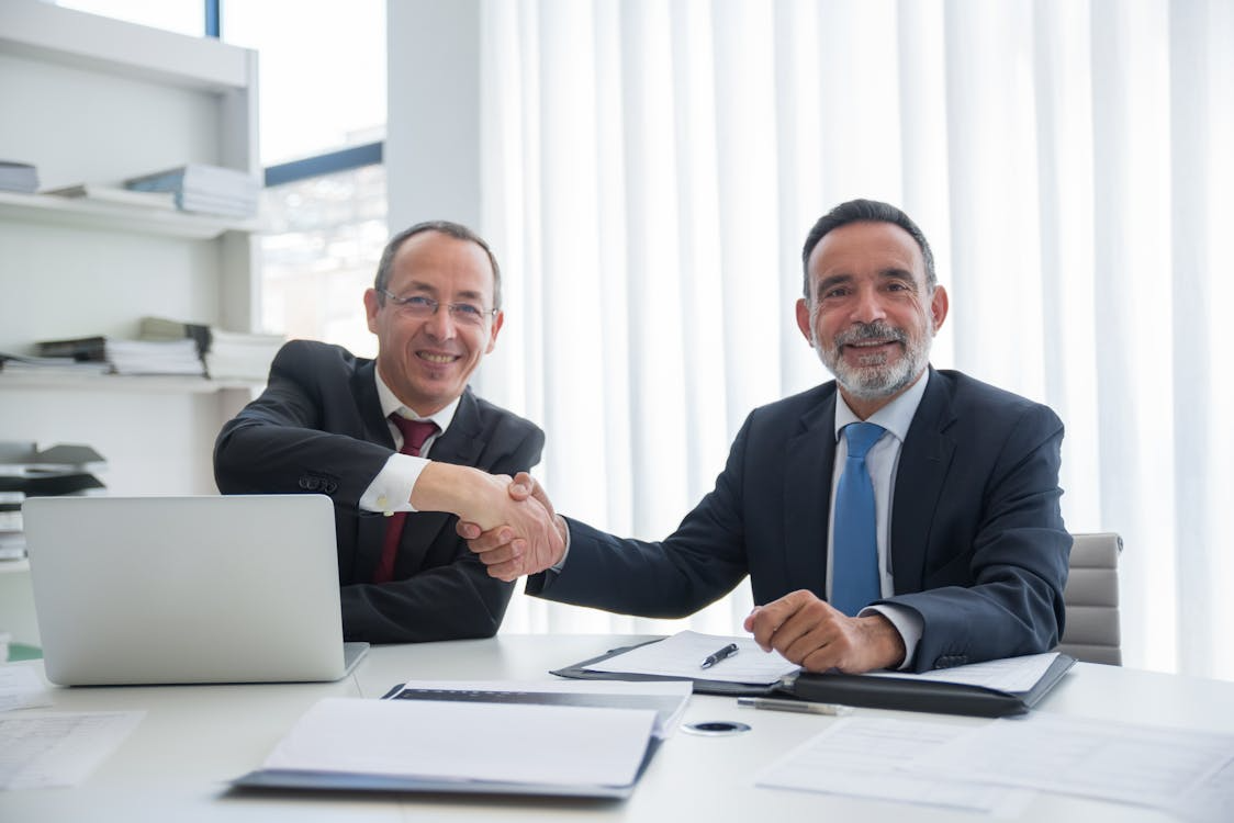 businessmen having a deal while doing handshake